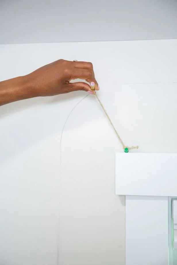 The next step in this DIY accent wall project is to draw curved portions of the border using a pencil on a string.